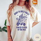 Comfort Colors tee in Ivory featuring cute sloth on a tricycle graphic with Born to Dilly Dally text