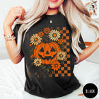 Comfort Colors tee in Black featuring retro floral jack-o'-lantern graphic with a checkered pattern side design