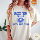 Comfort Colors tee in Ivory featuring screen printed raccoon graphic and Rizz Em With the Tism text