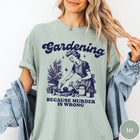 Comfort Colors tee in Bay featuring vintage style graphic of a woman gardening with text about murder.
