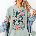 Comfort Colors tee in Bay featuring Easter religious floral graphic with He is Risen and Luke 24:6-7 text