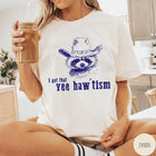 Comfort Colors tee in Ivory featuring western style graphic of a raccoon wearing a cowboy hat