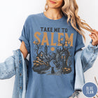 Comfort Colors tee in Blue Jean featuring vintage style Salem town scene with black cat and pumpkins