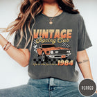 Comfort Colors tee in Pepper featuring vintage muscle car graphic with racing flags and 1984 text