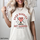 Comfort Colors tee in Natural featuring retro style sad heart character with horns and text graphic