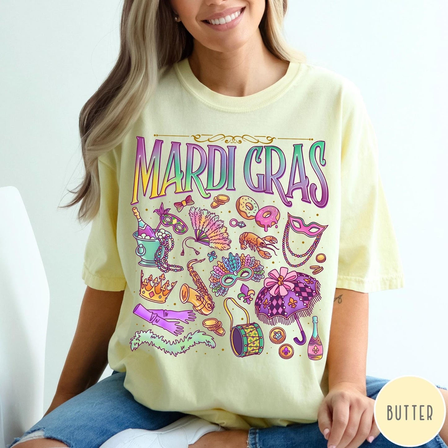 Comfort Colors tee in Butter featuring vintage style Mardi Gras celebration icons including masks, beads, and saxophone