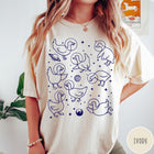Comfort Colors tee in Ivory featuring line art graphic of multiple geese wearing astronaut helmets in space