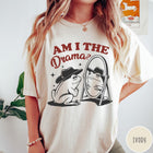 Comfort Colors tee in Ivory featuring whimsical frog graphic with a cowboy hat looking into a mirror