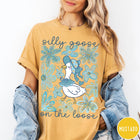 Comfort Colors tee in Mustard featuring whimsical graphic style with a goose wearing a bonnet and floral border