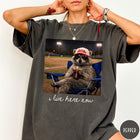 Comfort Colors tee in Pepper featuring graphic style raccoon wearing sunglasses and baseball cap at a stadium