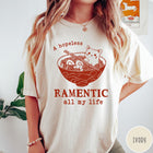 Comfort Colors tee in Ivory featuring line art graphic of a cute cat inside a ramen bowl