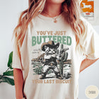 Comfort Colors tee in Ivory featuring western graphic design of a cat wearing a cowboy hat and gun.
