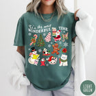 Comfort Colors tee in Light Green featuring Christmas collage graphic with Santa, snowman, animals, and holiday icons
