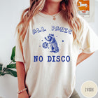 Comfort Colors tee in Ivory featuring screen printed raccoon graphic holding a disco ball with star accents
