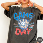 Comfort Colors tee in Pepper featuring baseball design with glove, ball, bat, and Game Day text graphic
