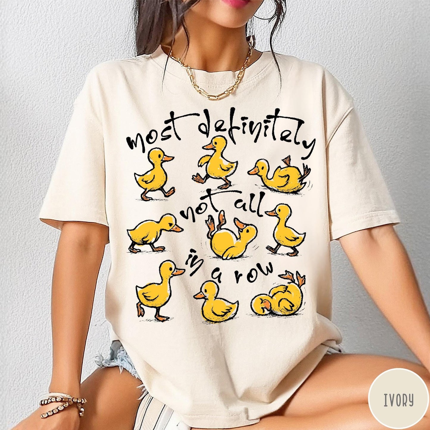 Comfort Colors tee in Ivory featuring whimsical duck graphic with text most definitely not all in a row.
