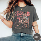 Comfort Colors tee in Pepper featuring western style graphic of a cowgirl riding a horse in the desert