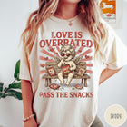 Comfort Colors tee in Ivory featuring vintage style graphic of a cherub eating snacks on a bench