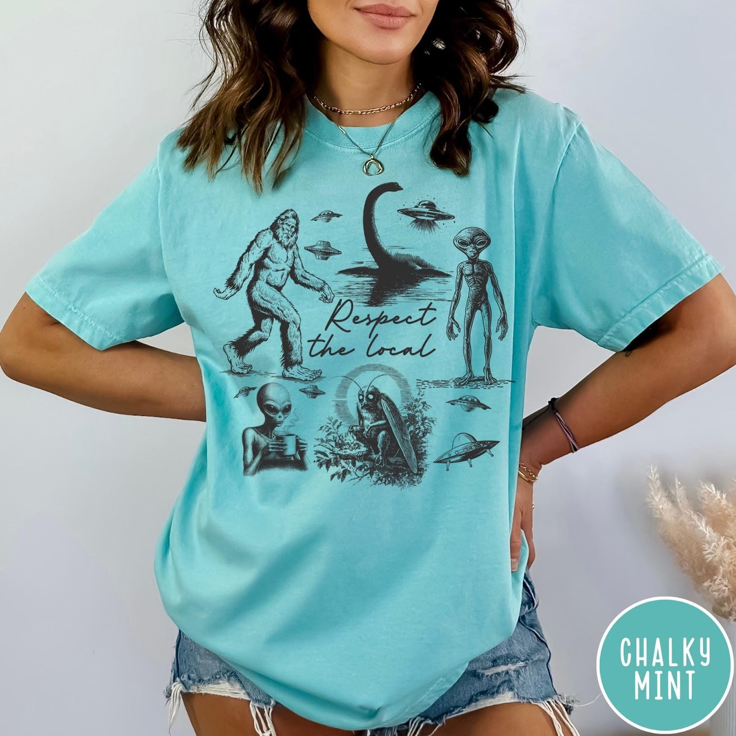 Comfort Colors tee in Chalky Mint featuring vintage style cryptid graphic with Bigfoot, UFOs, and alien creatures.