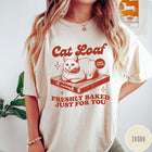 Comfort Colors tee in Ivory featuring graphic style cat loaf sitting on a wooden cutting board