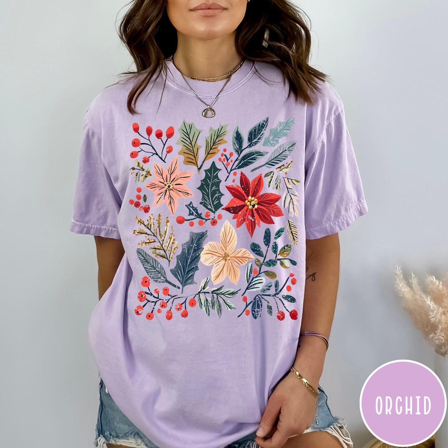Comfort Colors tee in Orchid featuring winter florals graphic with poinsettias, holly leaves, and red berries.