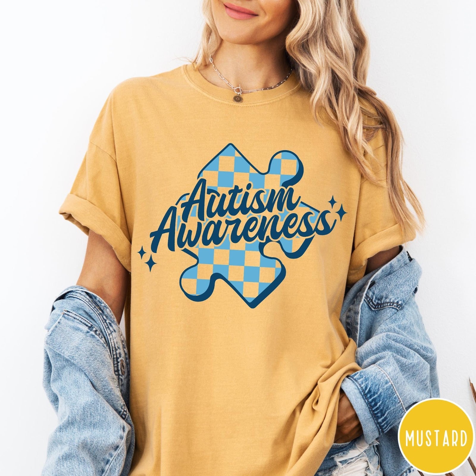 Comfort Colors tee in Mustard featuring casual style with a blue checkered puzzle piece Autism Awareness graphic