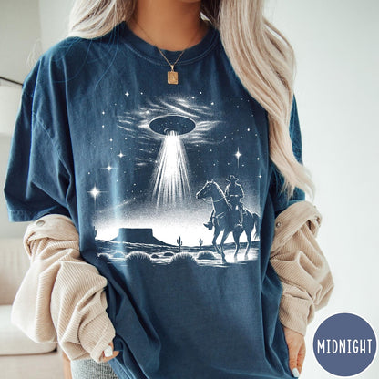 Comfort Colors tee in Midnight featuring western graphic style with a cowboy riding a horse under a UFO