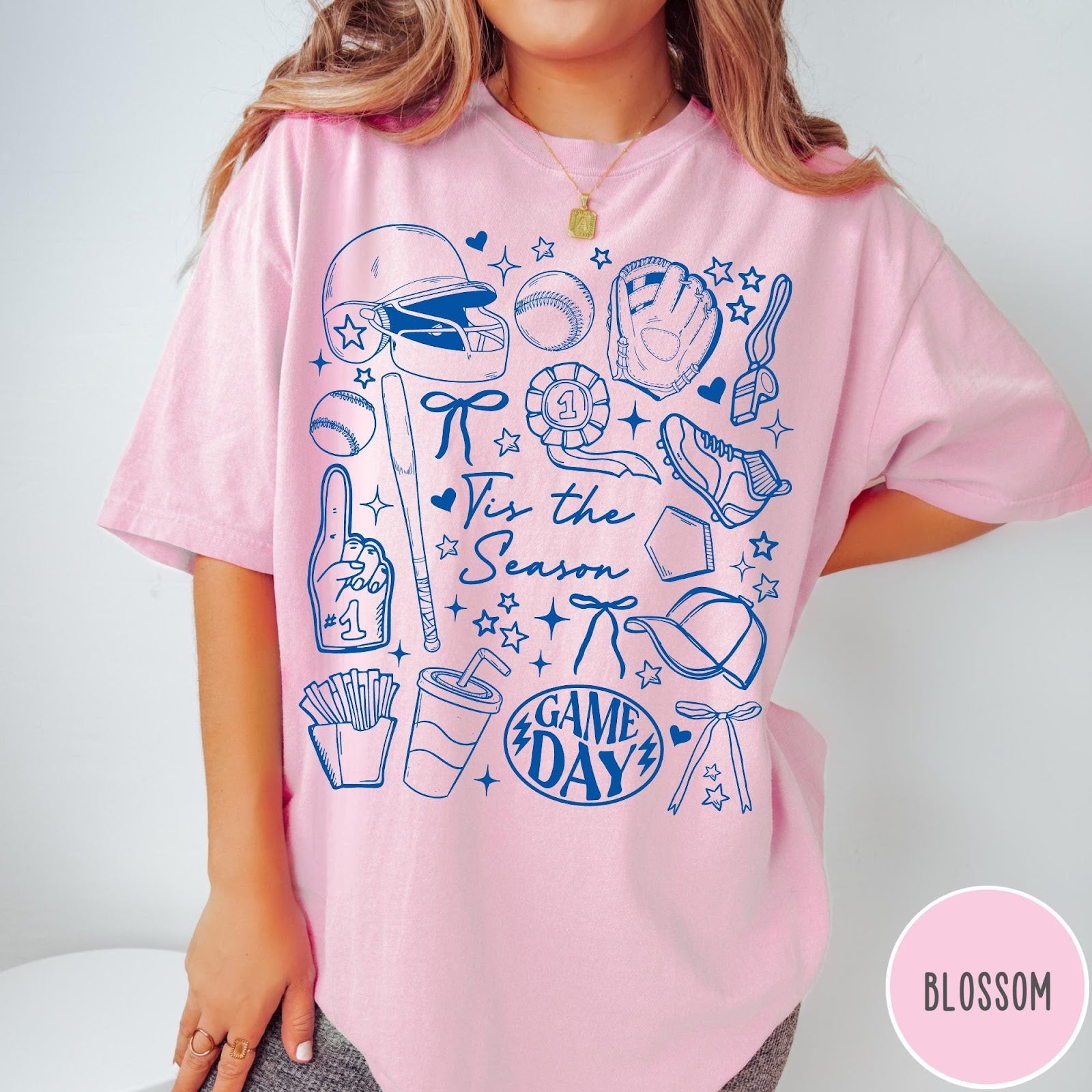 Comfort Colors tee in Blossom featuring baseball game day graphic with helmet, bat, ball, and snacks.