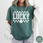 Comfort Colors tee in Light Green featuring checkerboard design with Lucky text and a shamrock graphic