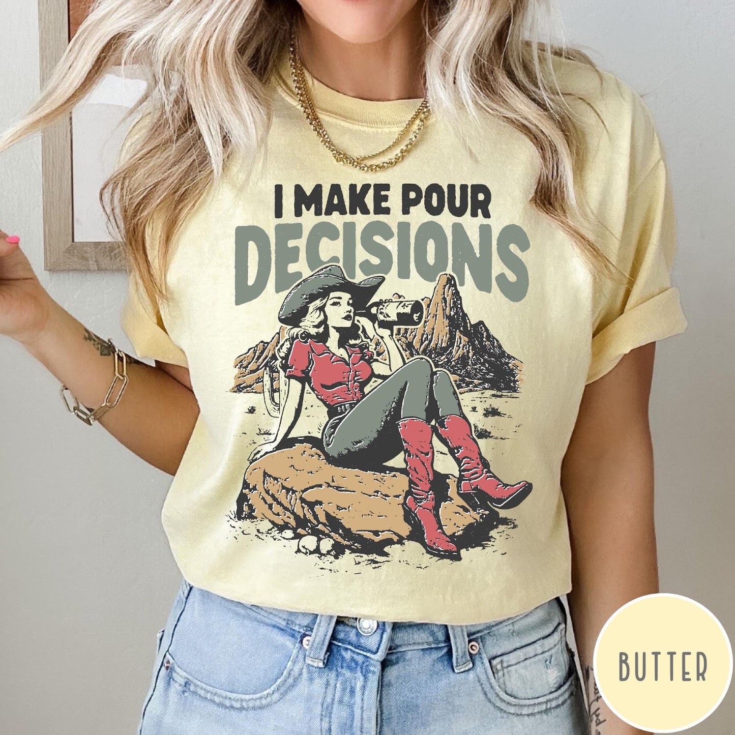Comfort Colors tee in Butter featuring western style graphic of a cowgirl sitting on a rock drinking