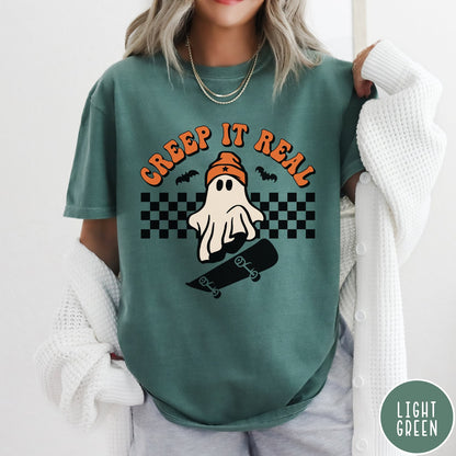 Comfort Colors tee in Light Green featuring retro style ghost graphic with skateboard and checkered background pattern