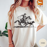 Comfort Colors tee in Ivory featuring western style graphic of a cowboy roping a calf on horseback