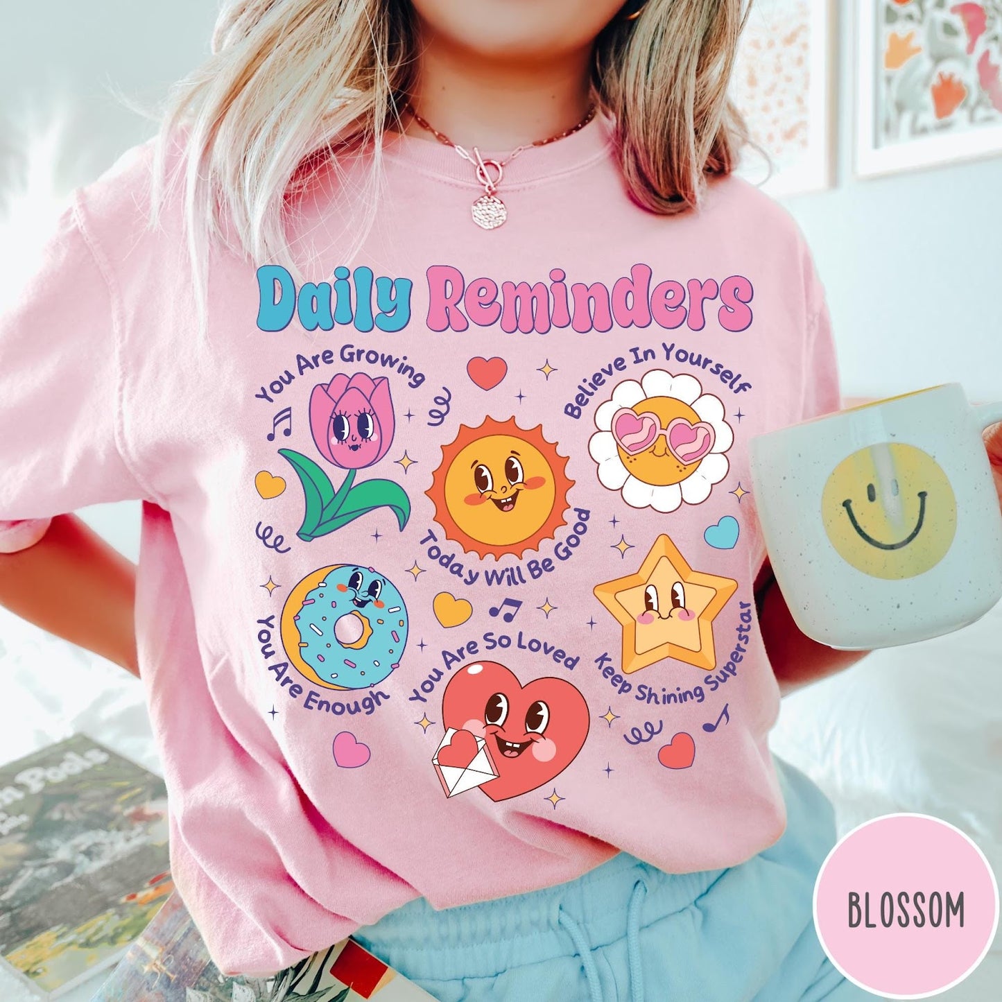 Comfort Colors tee in Blossom featuring retro mascot design with daily affirmations and colorful cartoon characters