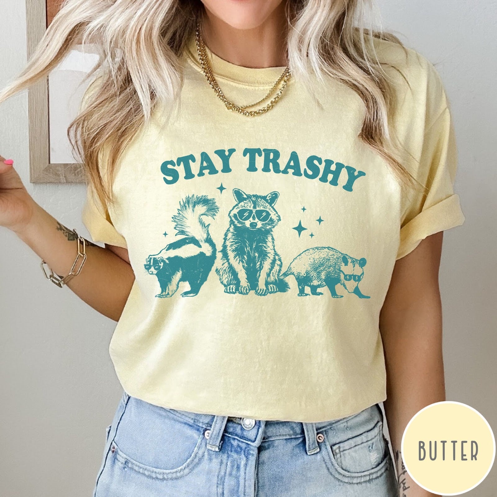 Comfort Colors tee in Butter featuring graphic style raccoon, skunk, and opossum wearing sunglasses with Stay Trashy text