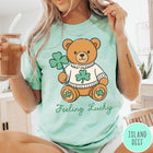 Comfort Colors tee in Island Reef featuring cute teddy bear graphic wearing a sweater with shamrocks