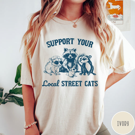 Comfort Colors tee in Ivory featuring illustration style graphic of a raccoon, opossum, and skunk wearing sunglasses