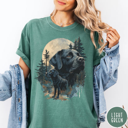 Comfort Colors tee in Light Green featuring nature style graphic of black Labrador dogs in a forest moon scene