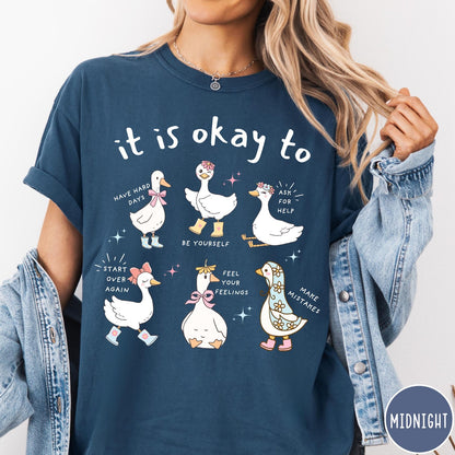 Comfort Colors tee in Midnight featuring whimsical graphic style with six cute geese and motivational text phrases
