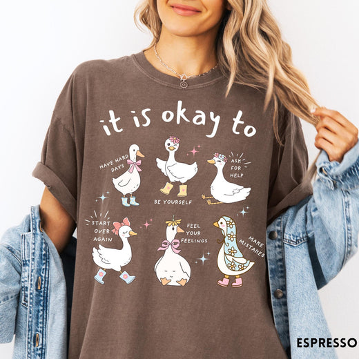 Comfort Colors tee in Espresso featuring whimsical graphic style with six cute geese and motivational text phrases