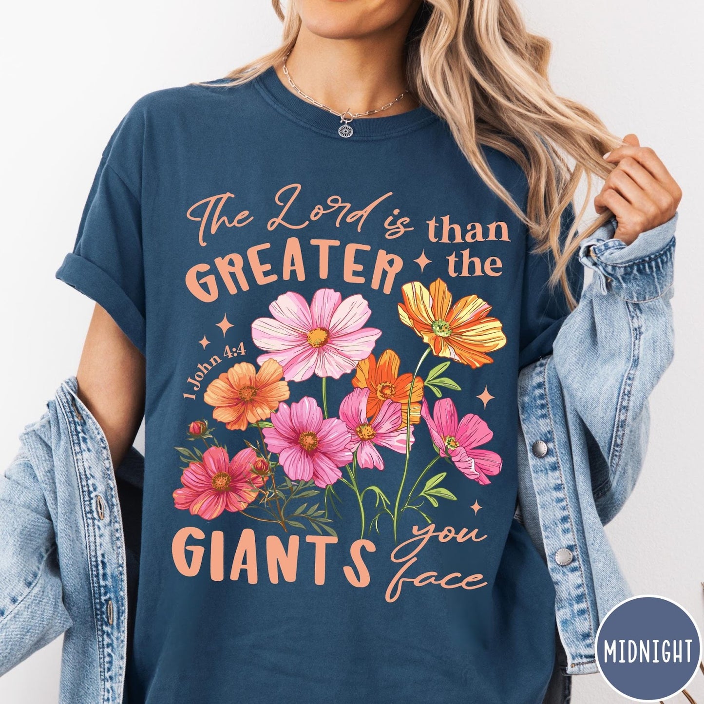 Comfort Colors tee in Midnight featuring floral graphic design with Bible verse The Lord is Greater text