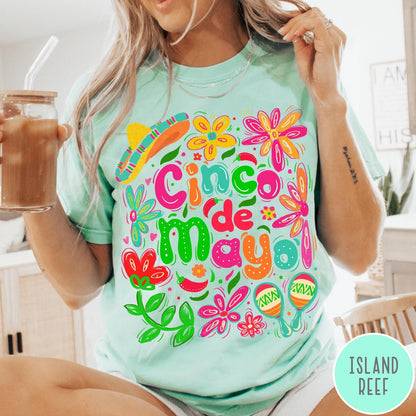 Comfort Colors tee in Island Reef featuring festive Cinco de Mayo graphic with flowers, sombrero, and maracas