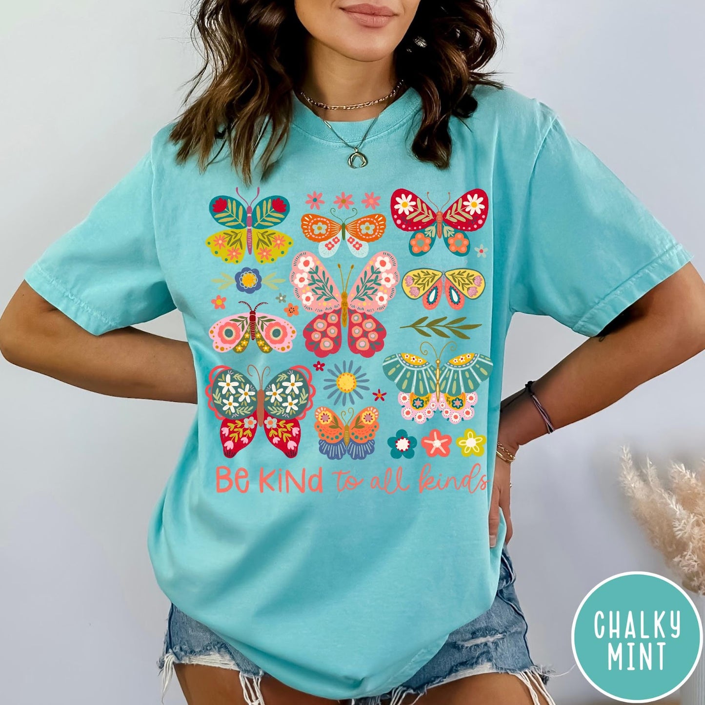 Comfort Colors tee in Chalky Mint featuring colorful butterfly and floral graphic with Be Kind to all kinds text