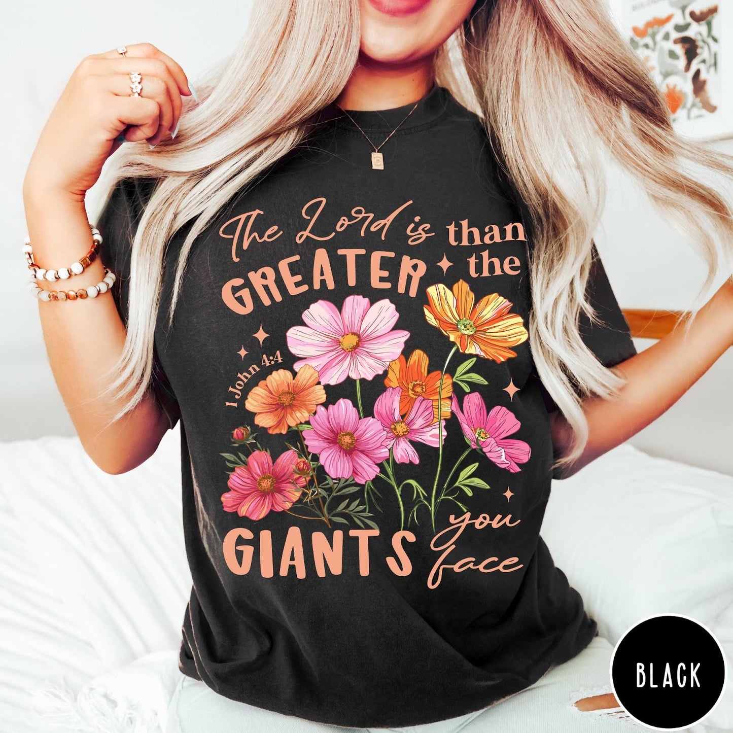 Comfort Colors tee in Black featuring floral graphic design with Bible verse The Lord is Greater text