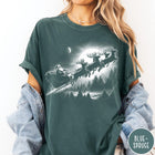 Comfort Colors tee in Blue Spruce featuring vintage style Santa Claus flying in a sleigh with reindeer