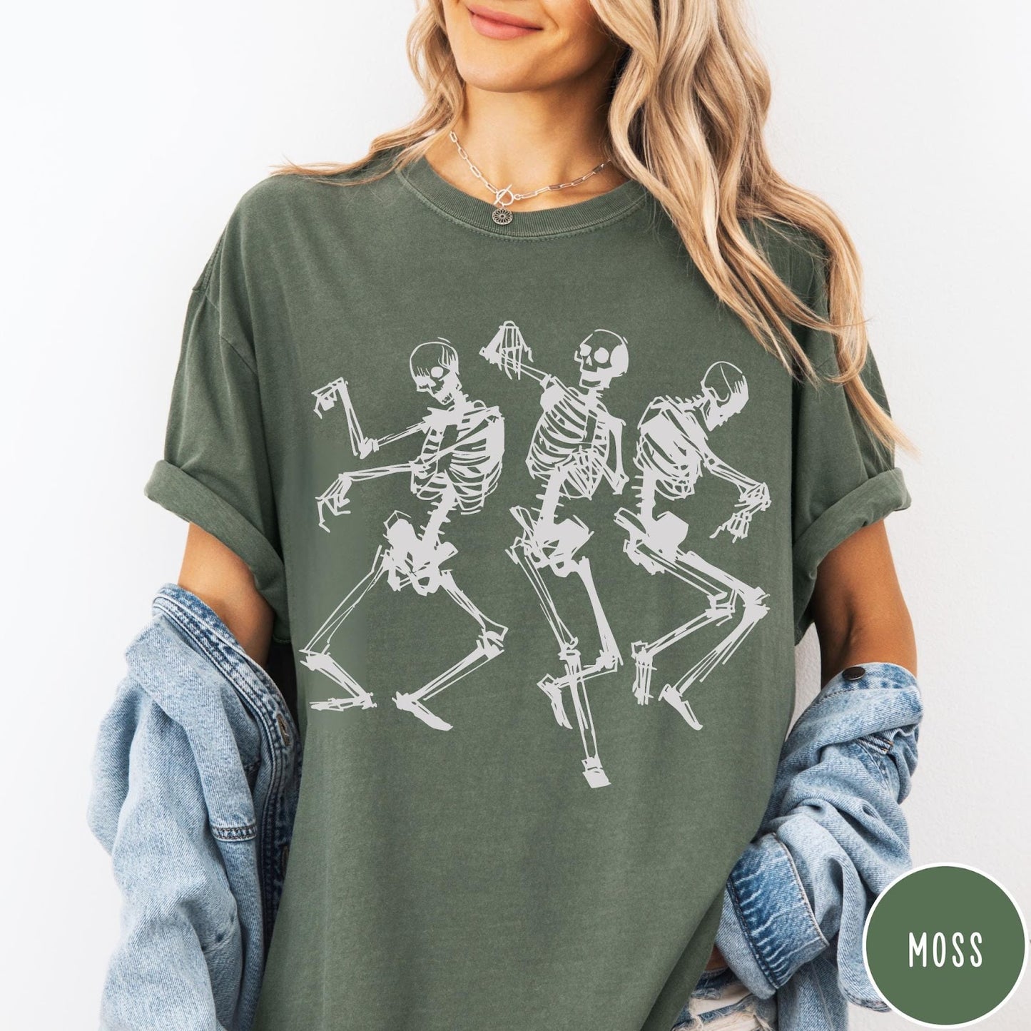 Comfort Colors tee in Moss featuring dancing skeletons graphic illustration on the front of the shirt