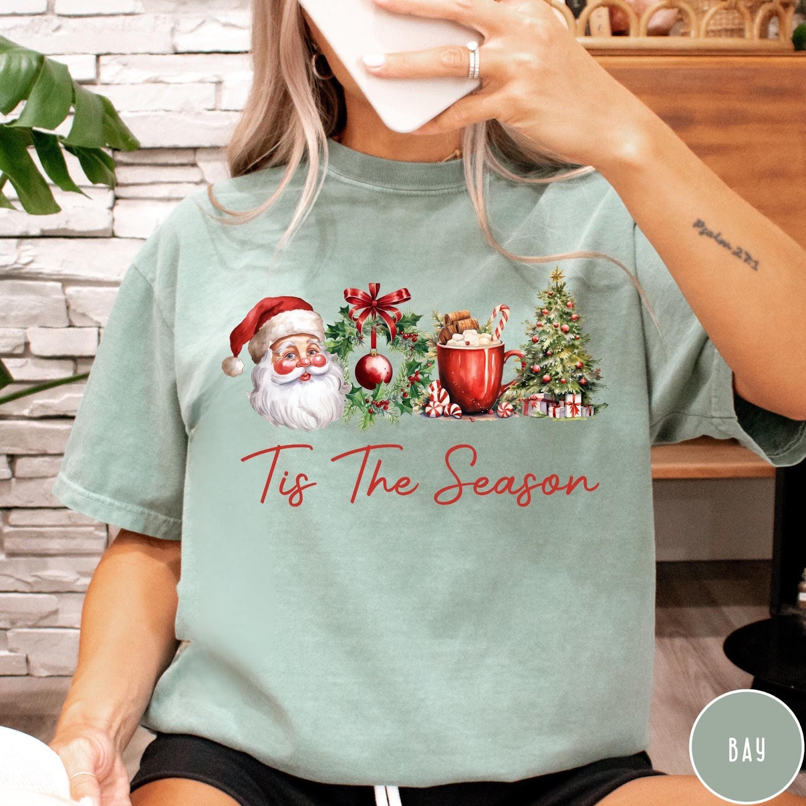 Comfort Colors tee in Bay featuring holiday design with Santa, wreath, hot cocoa, and Christmas tree graphic