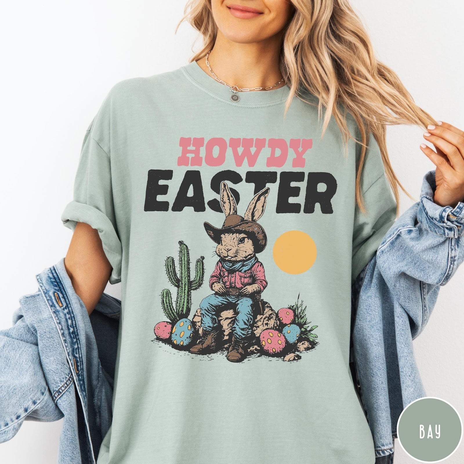 Comfort Colors tee in Bay featuring western graphic of a cowboy bunny sitting with cactus and eggs