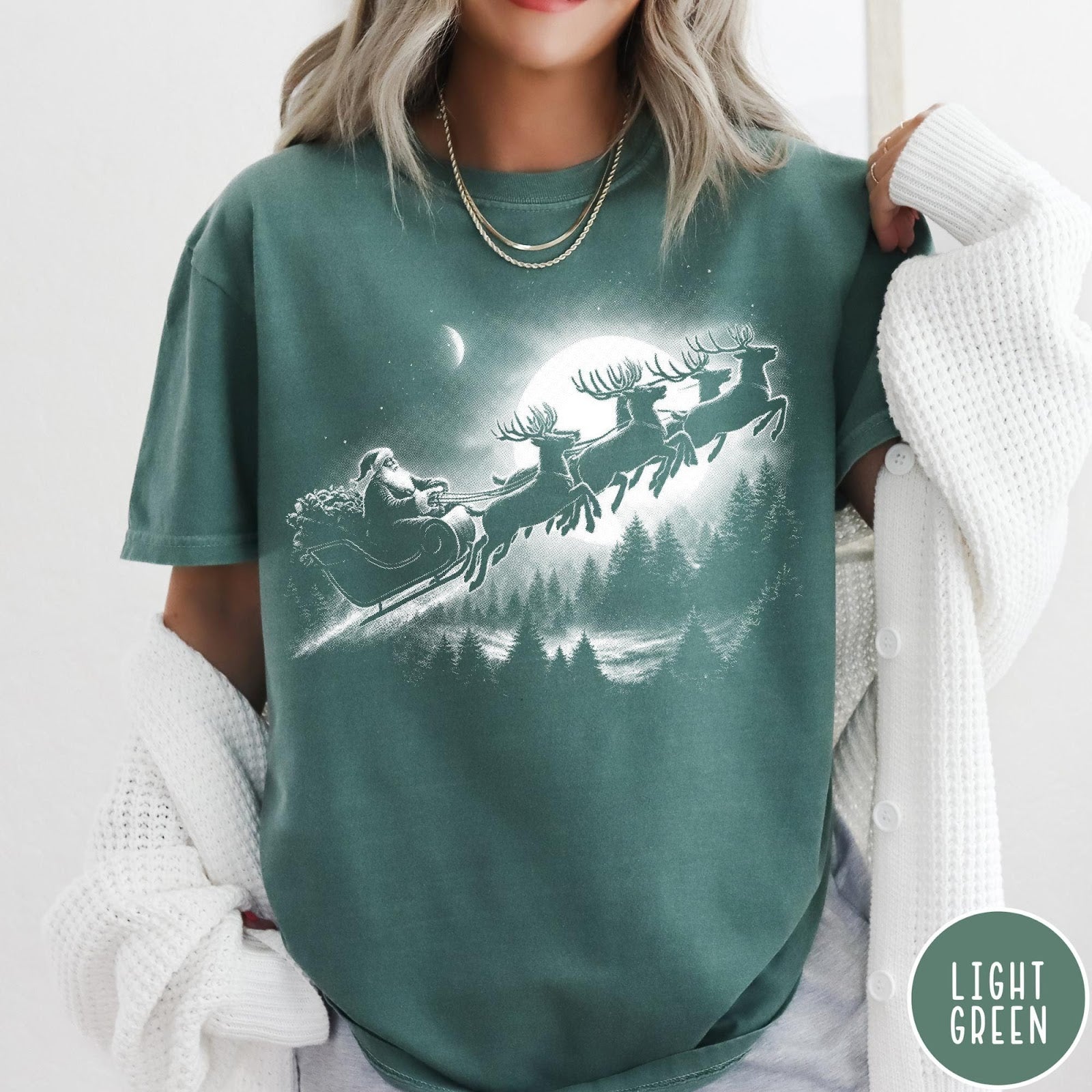 Comfort Colors tee in Light Green featuring vintage style Santa Claus flying in a sleigh with reindeer