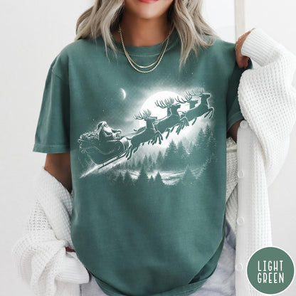 Comfort Colors tee in Light Green featuring vintage style Santa Claus flying in a sleigh with reindeer