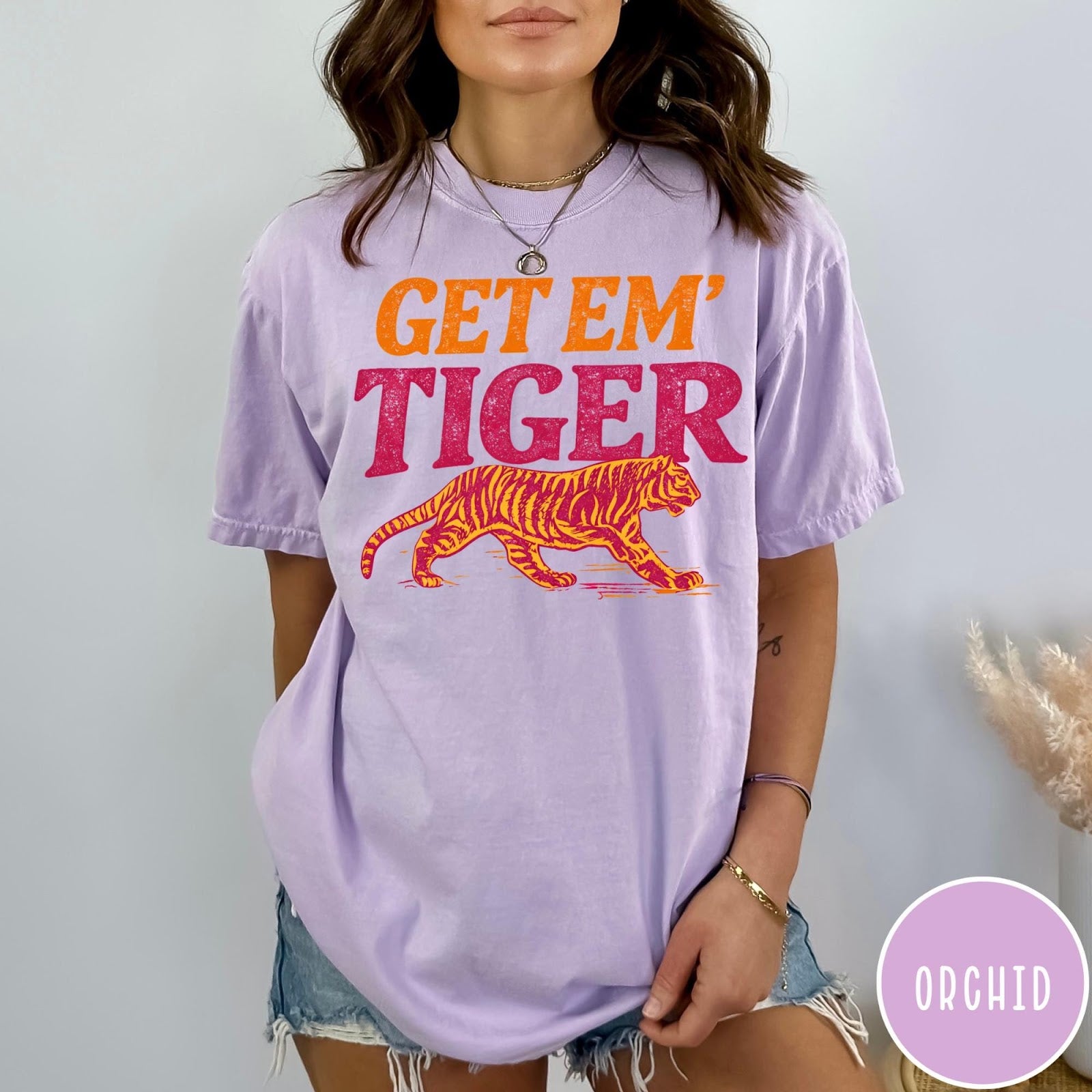 Comfort Colors tee in Orchid featuring vintage style graphic with orange text and a walking tiger illustration